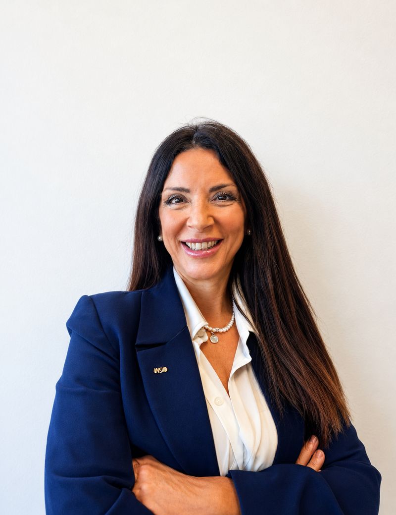 Ritratto di Eleonora Piazzese, sorridente, in giacca blu e camicia bianca